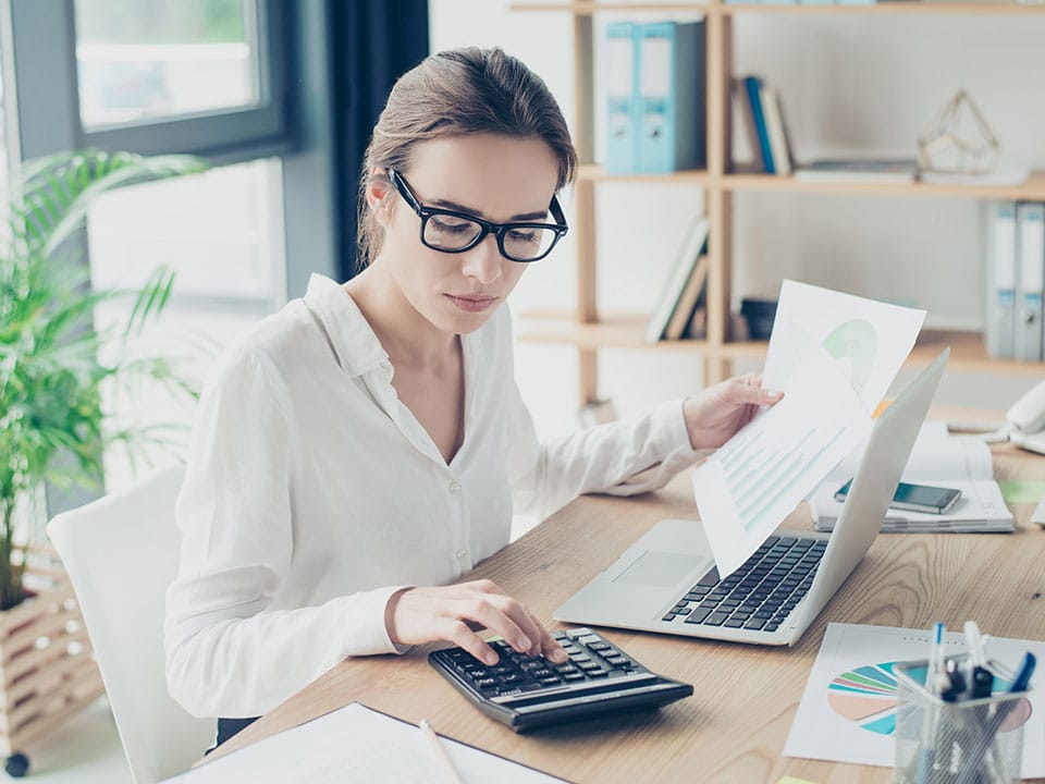 Accountant placed by an Albuquerque accounting recruiter using computer and calculator